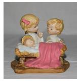 Angels kneeling before Baby Jesus figurine -