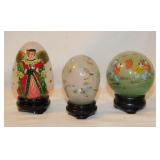 3 vintage reverse painted glass eggs on stands,