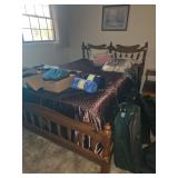 Full size bed with mattresses and bed spread.