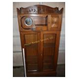 Antique glass front storage cabinet on wheels