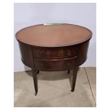 Mahogany side table features a distinctive oval