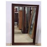 Mahogany wall mirror features a beveled edge and