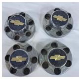 Four Chevy Hub Caps With 25 Plastic Lug Caps