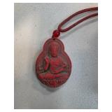 Red Carved Pendant Depicting Buddha with Cord Neck