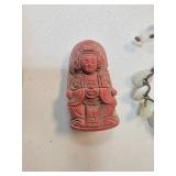 Red Figurine Depicting Seated Figure With Carved D