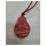 Red Carved Pendant with Religious Motif and Cord