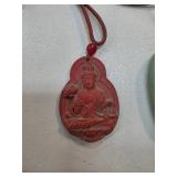 Carved Red Pendant Depicting Seated Figure with Co