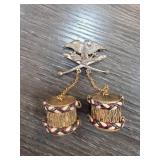 Brooch With Decorative Drums and Crossed Axes