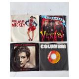 Four 45 RPM Vinyl Records in Sleeves