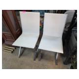 Two White Chairs With Chrome Legs