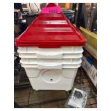 Red and White Feed Storage Bins With Accessories