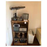Contents of Shelving Unit Including Lighting, Office Supplies, and Decor