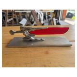 Chrome and Red Plastic Flying Lady Hood Ornament on Metal Base