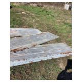 Building Material Lot: Metal Sheeting, Wood Planks, and Farm Trailer