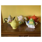 Collection of Five Ceramic Teapots Featuring Floral and Solid Color Designs