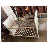 White Wooden Infant Crib with Slatted Railings and Floral Decor