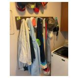Assorted Lot of Coats, Hats, and Cleaning Supplies on Wall Rack