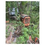 Orange Utility Tractor with Corrugated Hood in Overgrown Setting