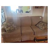 Three Cushion Sofa with Skirted Base and Two Decorative Pillows