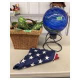 Assorted Decor Lot Including Woven Basket, Blue Swirl Gazing Ball with Stand, and US Flag