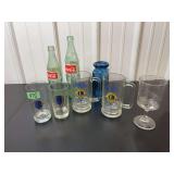 Assorted Collectible Glassware Lot Including Coca-Cola Bottles, Lions Club Mugs, and Kincaid Station Glass