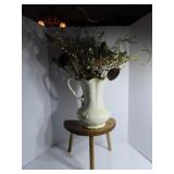 3 legged stool, ceramic pitcher, flowers.