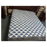 Small handmade quilt shown on a full-size bed