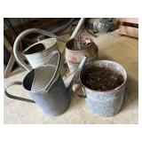 Two old metal watering cans and two metal