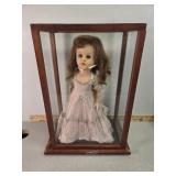 Porcelain doll in case with stand