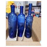 Three decorative blue glass bottles