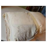 Two, covered and embroidered pillows