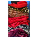 Fabrics, including reds, blacks and gray in bin