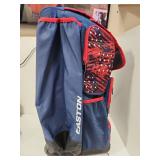 Navy blue and red Easton rolling baseball equipment bag featuring multiple compartments, padded straps, and decorative star pattern accents. Durable wheeled design ideal for transporting sports gear. 