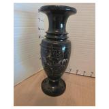 Vintage black marble vase with etched floral design and a black liquor bottle