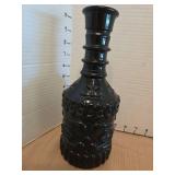 Vintage black marble vase with etched floral design and a black liquor bottle