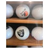 Sports teams golf ball collection in glass front hanging case