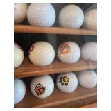 Sports teams golf ball collection in glass front hanging case