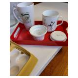 Tupperware deviled egg carrier, porcelain tea mug with lid and infuser on red plastic tray, lined basket, glass pitcher, more