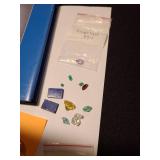 Gemstones, including reticulated quartz, amethyst, emeralds, green sapphire, garnet, more, plus a book