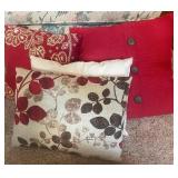 Assorted decorative throw pillows -- red, cream, & brown tones
