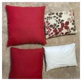 Assorted decorative throw pillows -- red, cream, & brown tones