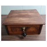 Antique Wood Box with ornate brass escutcheon and black wood drop pull handle.  Could be considered a small lap writing desk. 10.5" W x 11.25"D x  4.25" H