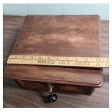 Antique Wood Box with ornate brass escutcheon and black wood drop pull handle.  Could be considered a small lap writing desk. 10.5" W x 11.25"D x  4.25" H