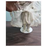 Antique German Made Bisque Doll in White Lace Dress with Ringlet Hair on stand - early 1900s