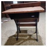 Antique American School Desk with Cast Iron Base and folding front chair. 22"W x 28"D x 30"H. Seat height 15". Desk height 26". Has finish wear and markings on the wood.
