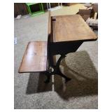 Antique American School Desk with Cast Iron Base and folding front chair. 22"W x 28"D x 30"H. Seat height 15". Desk height 26". Has finish wear and markings on the wood.
