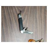 Outers Gun Cleaning Kit , a few vintage bullets, picket knife, and an acrylic keychain with an airplane inside