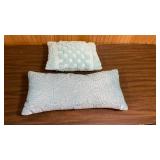 Decorative bed pillows in light blue/light turquoise - one has puffy checkerboard pattern, the other is a bolster pillow embellished with beads