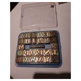 Metal alphabet stamps in storage tray