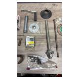 Collection of hardware items including metal fasteners, threaded rods, grinding wheel, metal hook tool, screws, palm sander and more